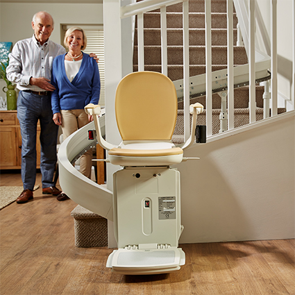 Stairlift with man and woman behind it